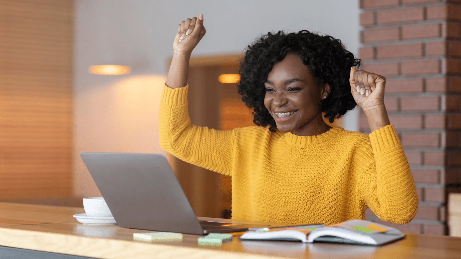 a person sitting at a table jubilation with hands up